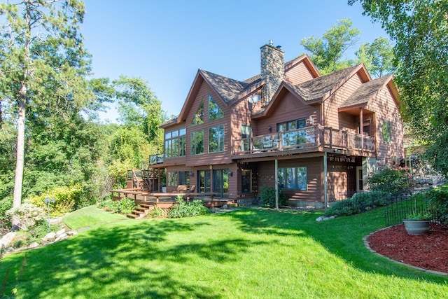 back of house featuring a lawn, a chimney, and a wooden deck