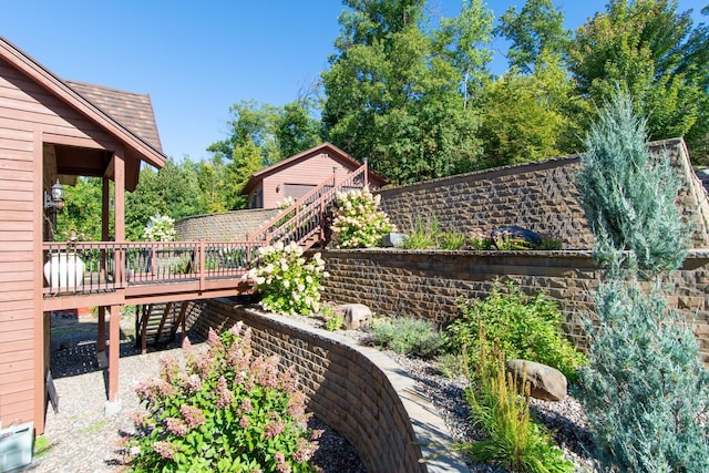 view of yard featuring fence, a wooden deck, and stairs