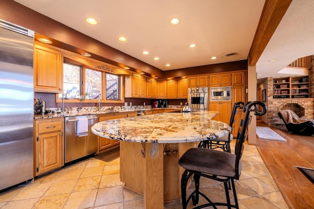 kitchen with recessed lighting, built in appliances, light stone countertops, and stone tile flooring