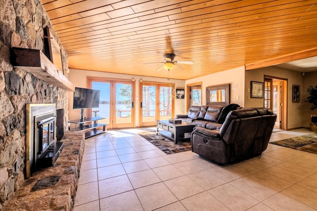 living room featuring light tile patterned floors, french doors, a ceiling fan, and wooden ceiling