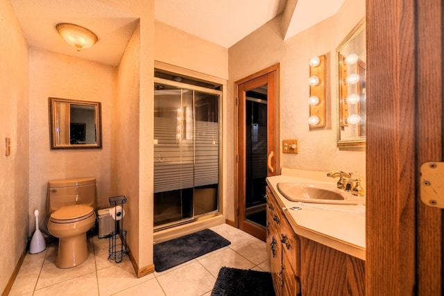bathroom featuring tile patterned flooring, toilet, a shower stall, and vanity