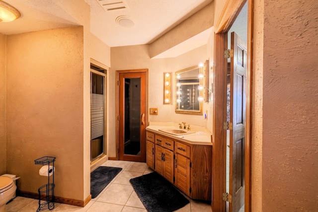 full bathroom with a shower stall, tile patterned flooring, vanity, and a textured wall
