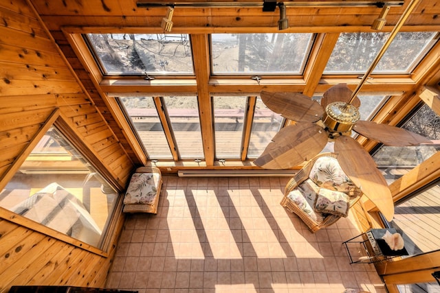 unfurnished sunroom featuring track lighting, wooden walls, and tile patterned flooring