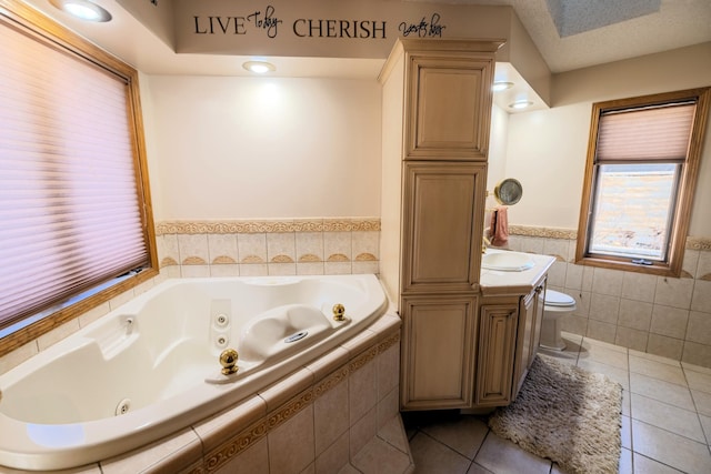 bathroom featuring tile patterned flooring, tile walls, toilet, and a whirlpool tub