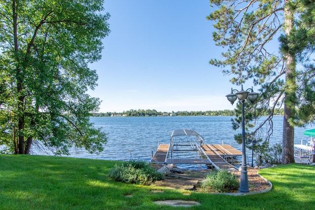 dock area with a yard and a water view