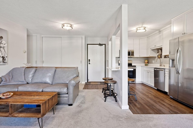 living area featuring dark colored carpet and a textured ceiling