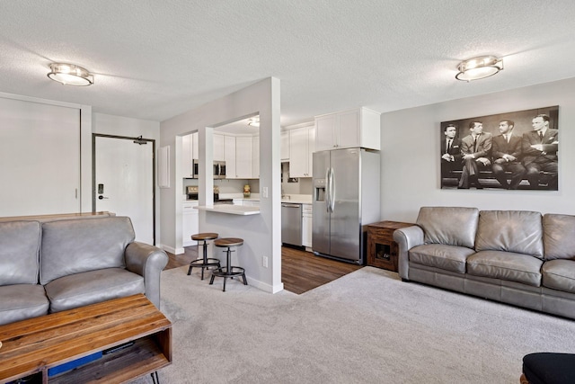carpeted living room featuring a textured ceiling and baseboards