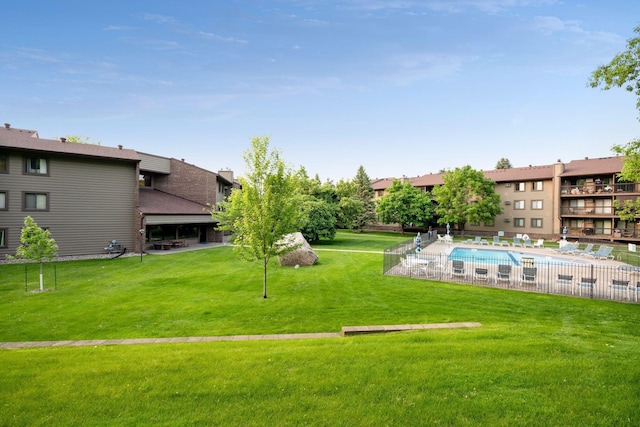 view of home's community featuring a lawn, a swimming pool, and a patio area