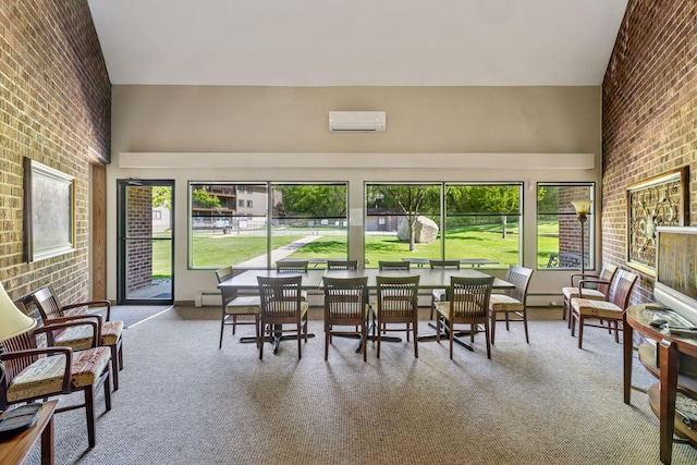 sunroom / solarium with brick wall, an AC wall unit, carpet floors, a high ceiling, and baseboard heating