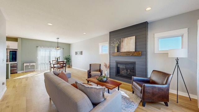 577 Keefe Ct NW, Eyota, MN 55934 - living area with a fireplace, baseboards, light wood finished floors, and recessed lighting