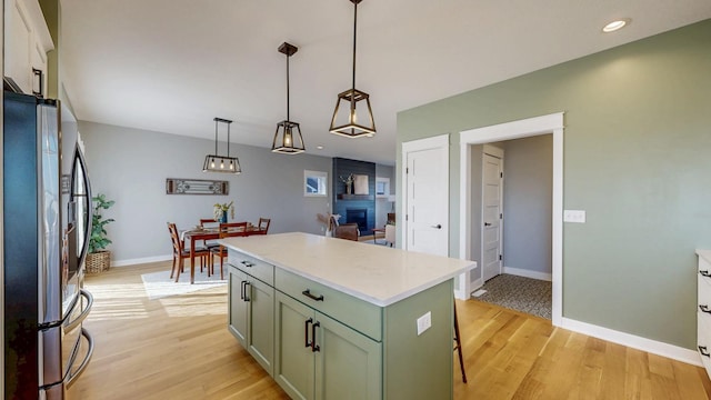 577 Keefe Ct NW, Eyota, MN 55934 - kitchen with stainless steel fridge with ice dispenser, green cabinetry, light wood-style floors, light countertops, and baseboards