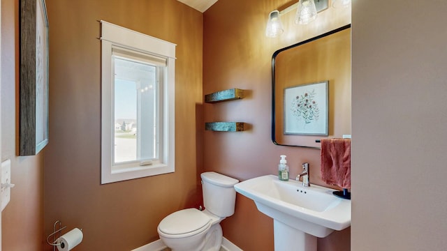 577 Keefe Ct NW, Eyota, MN 55934 - half bathroom featuring toilet, a sink, and baseboards