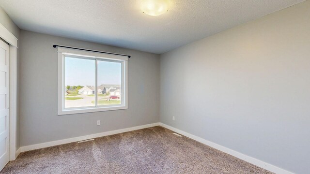 577 Keefe Ct NW, Eyota, MN 55934 - carpeted empty room featuring baseboards and a textured ceiling
