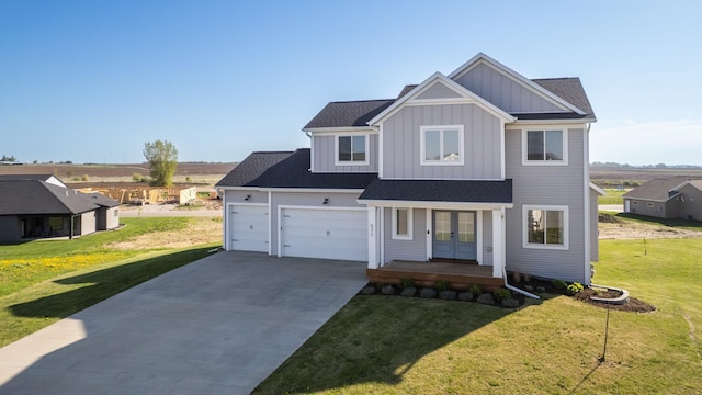 577 Keefe Ct NW, Eyota, MN 55934 - view of front of home with french doors, board and batten siding, driveway, a front lawn, and an attached garage