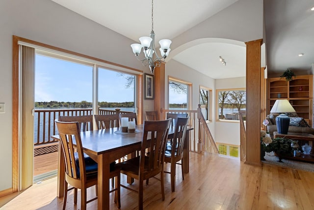 46463 Cambridge Dr, Stanchfield, MN 55080 - dining area with light wood-type flooring, arched walkways, a chandelier, a water view, and vaulted ceiling