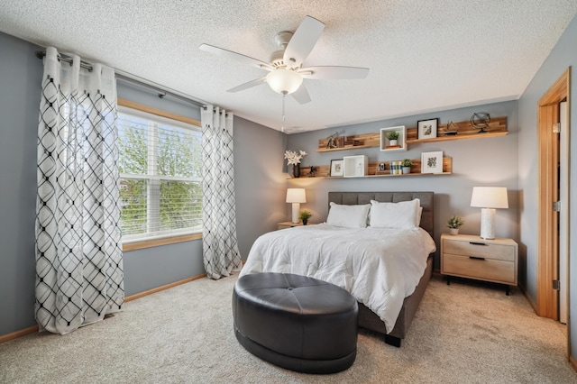 bedroom featuring carpet, a textured ceiling, baseboards, and a ceiling fan