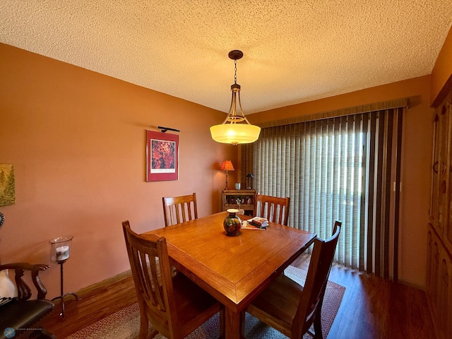 dining room featuring a textured ceiling and wood finished floors