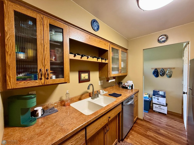 kitchen featuring a sink, glass insert cabinets, stainless steel dishwasher, and wood finished floors