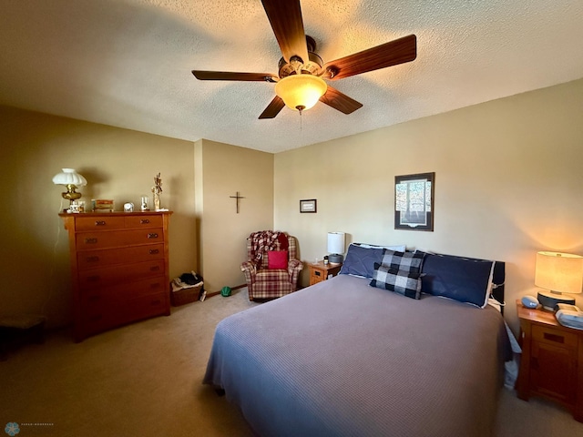 bedroom with a textured ceiling, carpet, and a ceiling fan