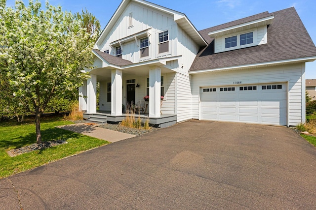 11464 Wagon Wheel Curv, Woodbury, MN 55129 - view of front of house featuring covered porch, driveway, roof with shingles, board and batten siding, and a garage