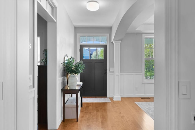 11464 Wagon Wheel Curv, Woodbury, MN 55129 - foyer entrance with light wood-style floors, wainscoting, healthy amount of natural light, arched walkways, and ornate columns
