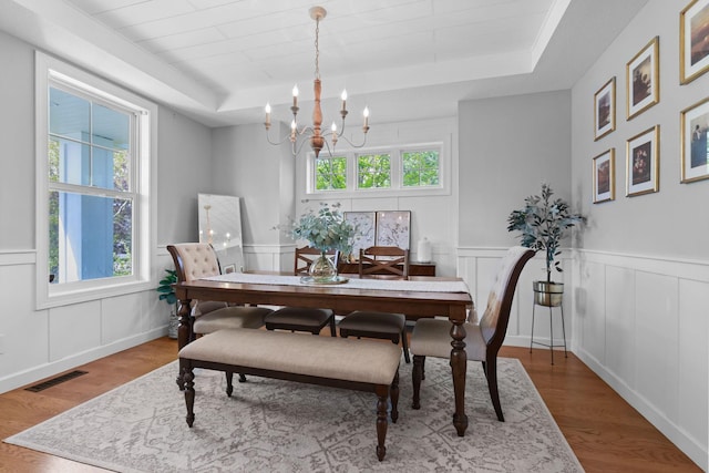 11464 Wagon Wheel Curv, Woodbury, MN 55129 - dining room with a tray ceiling, a chandelier, wood finished floors, a decorative wall, and wainscoting