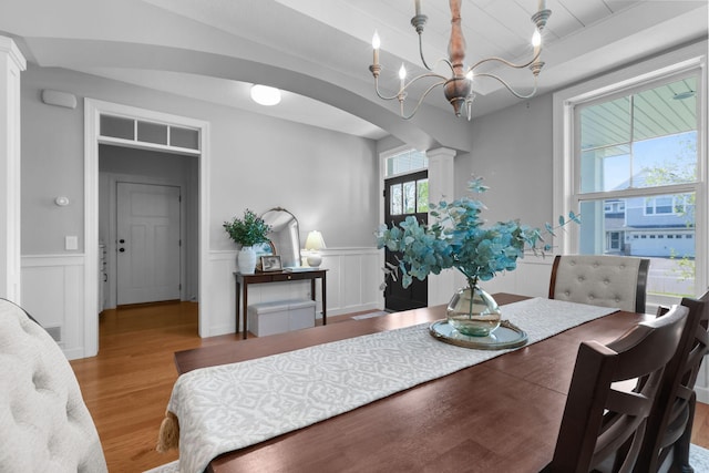 11464 Wagon Wheel Curv, Woodbury, MN 55129 - dining area featuring ornate columns, wood finished floors, arched walkways, wainscoting, and a decorative wall