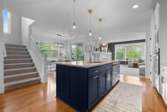 11464 Wagon Wheel Curv, Woodbury, MN 55129 - kitchen featuring open floor plan, a sink, stainless steel appliances, light wood-style floors, and healthy amount of natural light