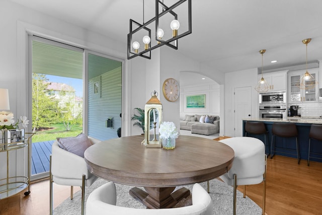 11464 Wagon Wheel Curv, Woodbury, MN 55129 - dining room with a chandelier, arched walkways, light wood-style flooring, and recessed lighting