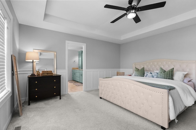 11464 Wagon Wheel Curv, Woodbury, MN 55129 - bedroom featuring carpet, a tray ceiling, connected bathroom, a wainscoted wall, and a ceiling fan
