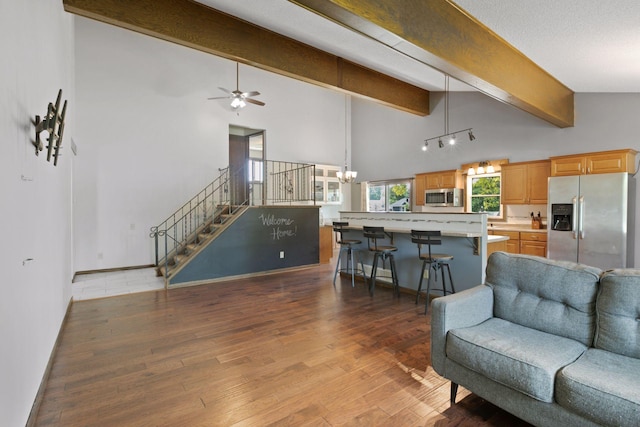 7900 Idaho Cir N, Brooklyn Park, MN 55445 - living room featuring beamed ceiling, wood finished floors, stairway, a ceiling fan, and a chandelier