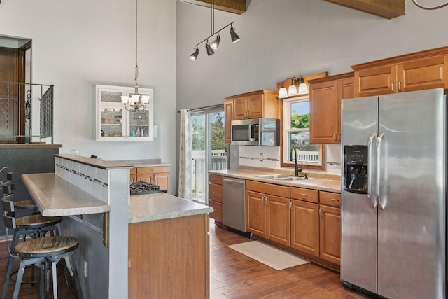 7900 Idaho Cir N, Brooklyn Park, MN 55445 - kitchen with appliances with stainless steel finishes, a sink, high vaulted ceiling, dark wood finished floors, and light countertops