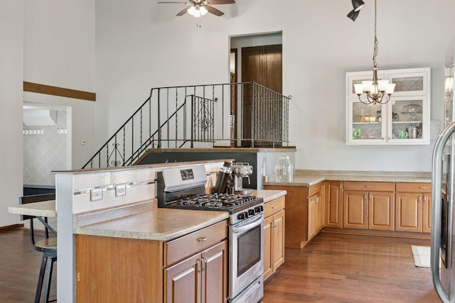 7900 Idaho Cir N, Brooklyn Park, MN 55445 - kitchen with stainless steel gas range, wood finished floors, a chandelier, a ceiling fan, and light countertops