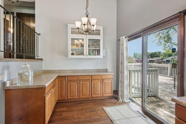 7900 Idaho Cir N, Brooklyn Park, MN 55445 - kitchen featuring dark wood finished floors, a chandelier, light countertops, pendant lighting, and a high ceiling