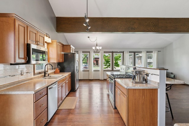 7900 Idaho Cir N, Brooklyn Park, MN 55445 - kitchen featuring appliances with stainless steel finishes, a sink, a kitchen breakfast bar, wood-type flooring, and a center island