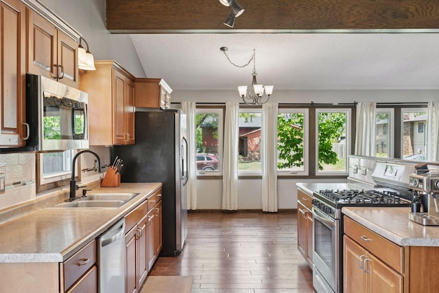 7900 Idaho Cir N, Brooklyn Park, MN 55445 - kitchen featuring appliances with stainless steel finishes, a sink, light countertops, decorative backsplash, and a chandelier