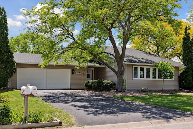7900 Idaho Cir N, Brooklyn Park, MN 55445 - view of front of house featuring asphalt driveway and an attached garage
