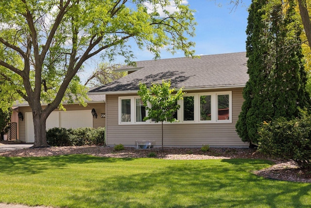 7900 Idaho Cir N, Brooklyn Park, MN 55445 - view of front of home featuring an attached garage, a front lawn, and roof with shingles