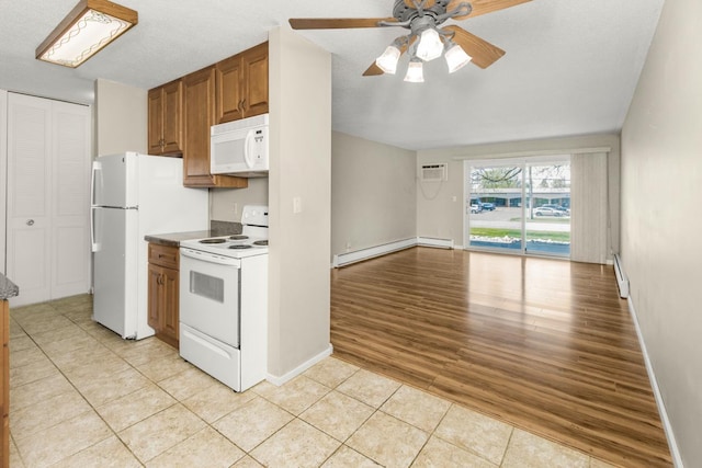 kitchen featuring white appliances, a baseboard radiator, brown cabinetry, and light tile patterned flooring