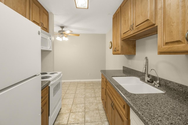 kitchen with white appliances, a sink, a ceiling fan, brown cabinetry, and dark stone countertops