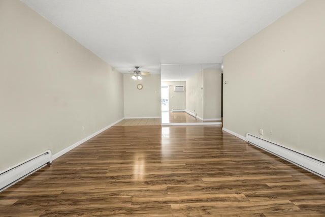 unfurnished room featuring baseboard heating, ceiling fan, wood finished floors, and baseboards
