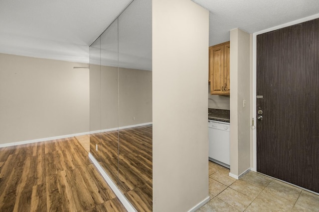 corridor with light wood-type flooring and baseboards