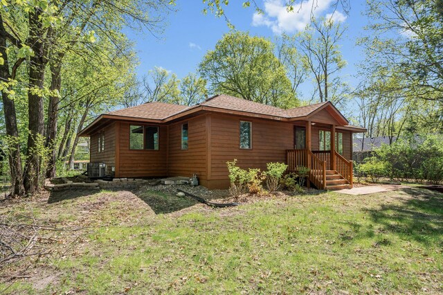 25985 Smithtown Rd, Shorewood, MN 55331 - view of side of home featuring central air condition unit, a lawn, and roof with shingles