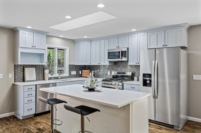 25985 Smithtown Rd, Shorewood, MN 55331 - kitchen featuring stainless steel appliances, a sink, a skylight, a center island, and dark wood-style flooring