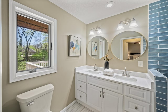 25985 Smithtown Rd, Shorewood, MN 55331 - full bathroom featuring toilet, double vanity, baseboards, and tile patterned floors