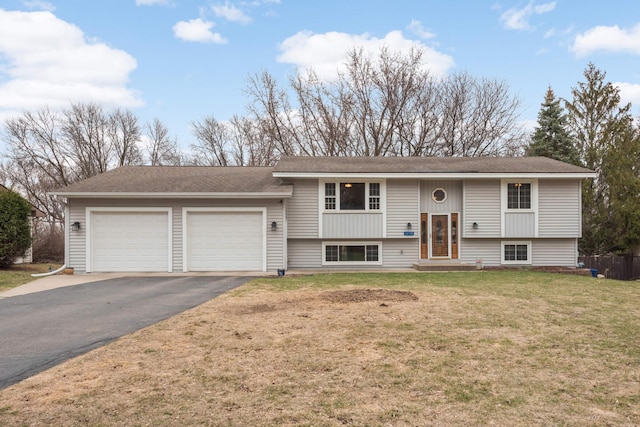 split foyer home featuring driveway, an attached garage, and a front yard