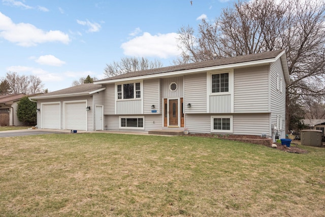 bi-level home with an attached garage, a front lawn, and driveway