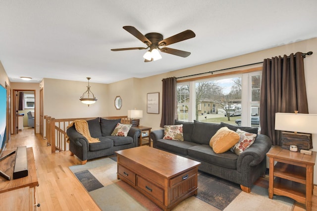 living area with a ceiling fan and light wood-style floors