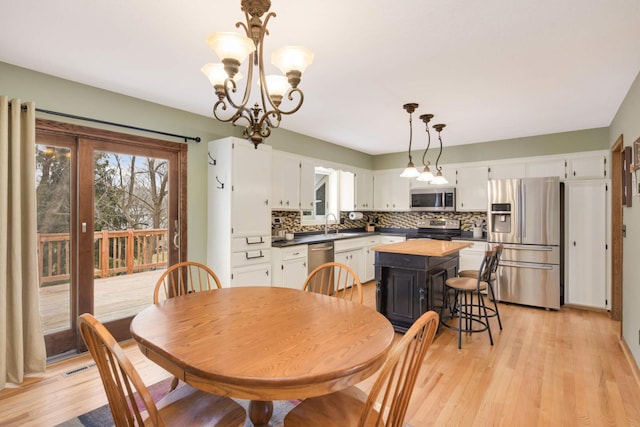 dining room with a notable chandelier, visible vents, and light wood-style floors
