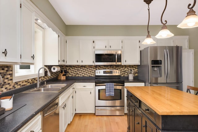 kitchen with white cabinetry, stainless steel appliances, and a sink